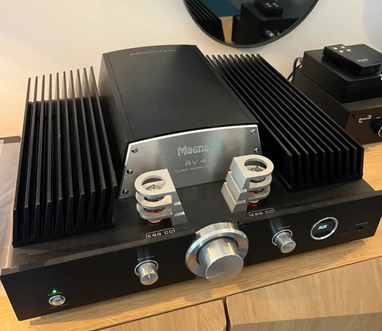 Amplificateur à tubes Magnat RV4 noir en situation sur un meuble en bois clair, lampes E88CC apparentes