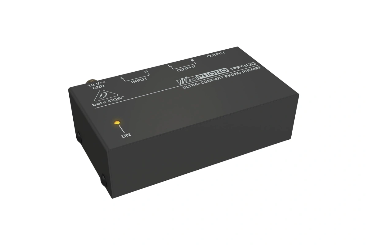 Préampli phono Behringer Microphono PP400 vue trois-quarts, boîtier plastique noir ultra-compact avec LED rouge d'alimentation frontale