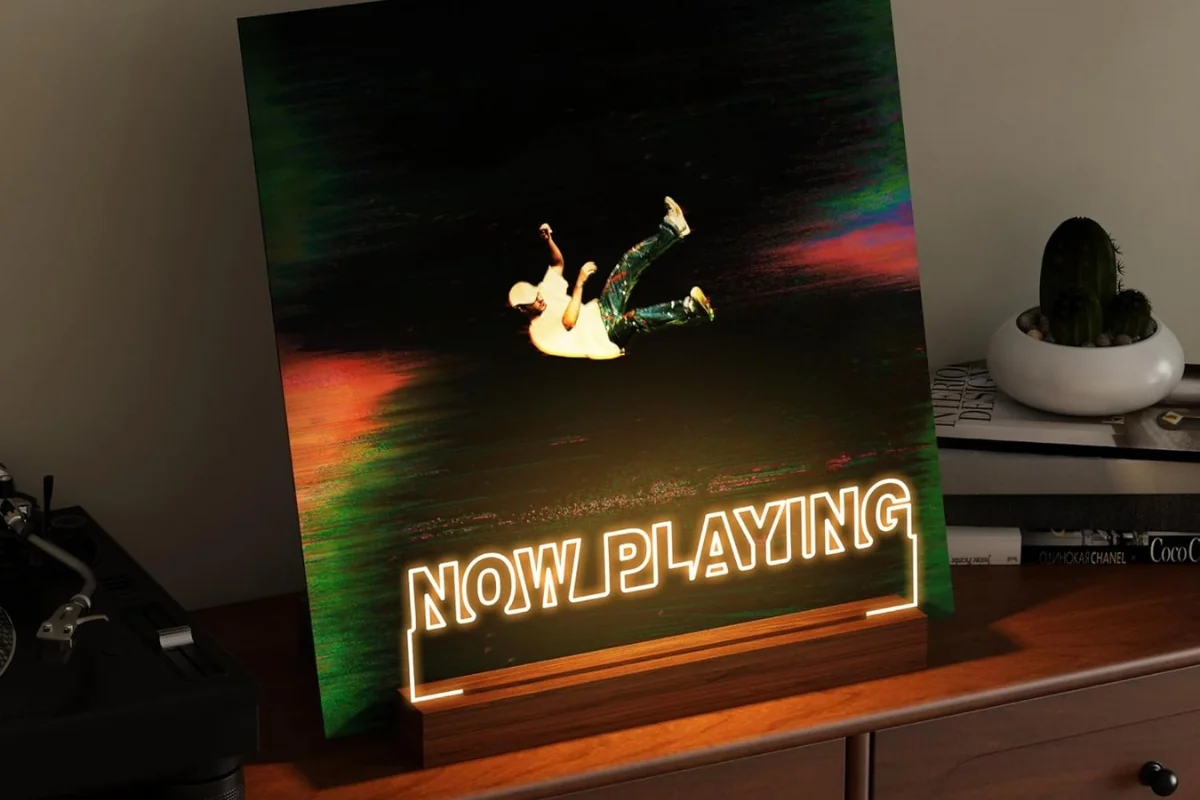 Présentoir lumineux Now Playing exposant la pochette du vinyle en cours d'écoute près de la platine