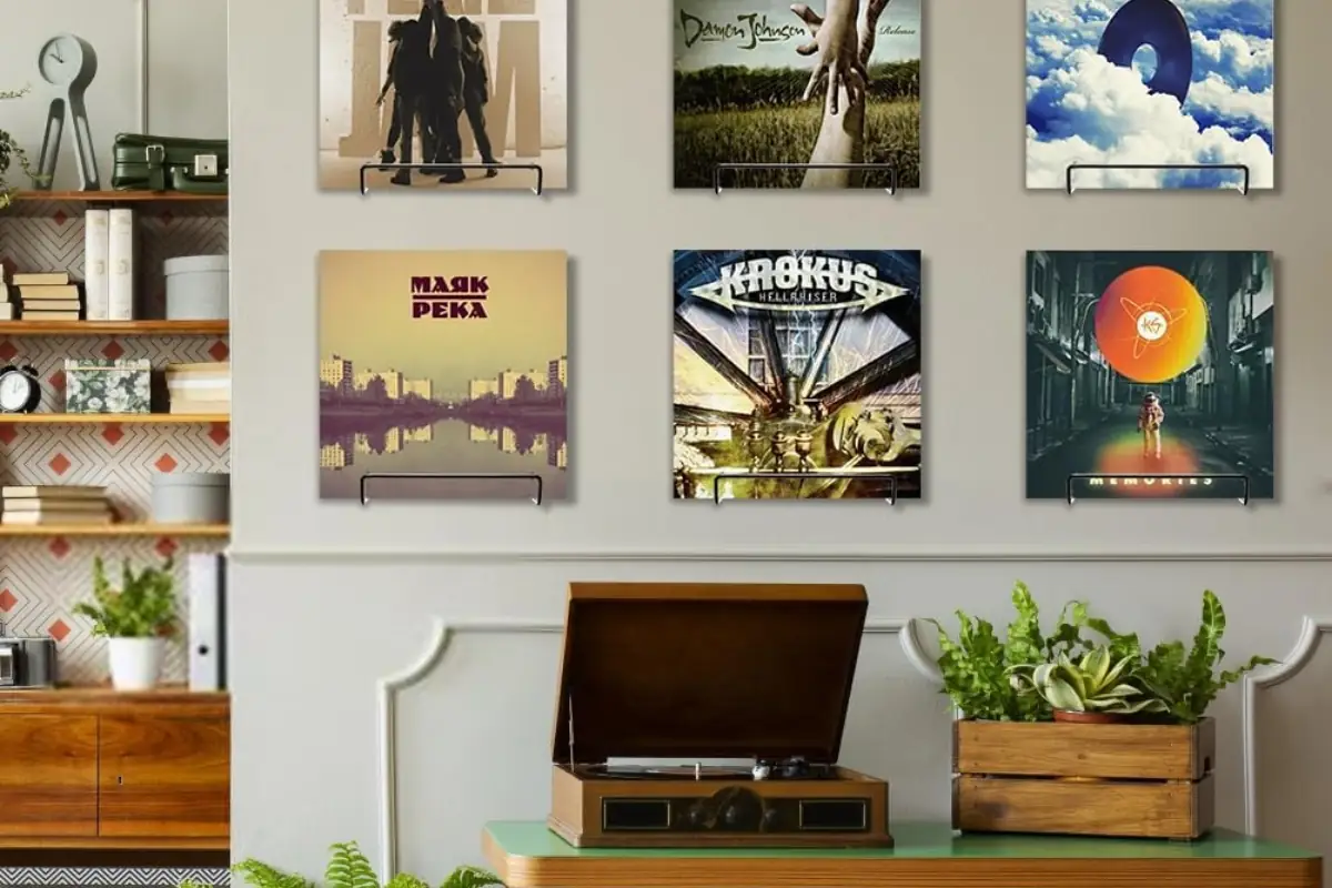 Mur de pochettes de vinyle exposées sur supports muraux au-dessus d'un meuble avec platine